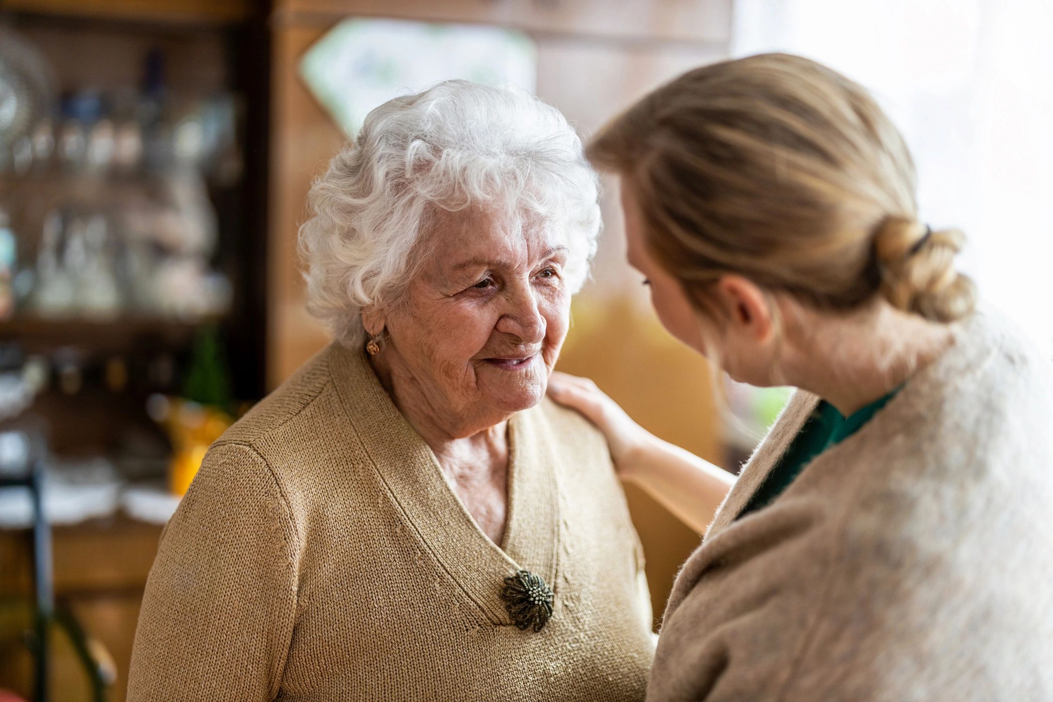 Caregiver talking with senior woman during a home visit