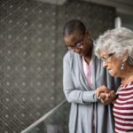 Nurse helping a senior woman walking the stairs
