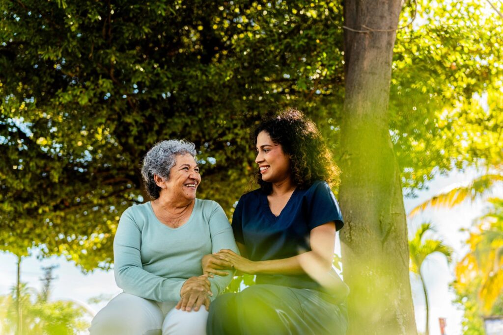 Home caregiver and senior woman talking outdoors